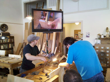 Demonstrating sawing with a video close-up.